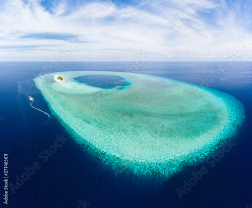 Aerial: tropical atoll view from above, blue lagoon turquoise water coral reef, Wakatobi Marine National Park, Indonesia - concept travel destination Maldives Polinesia