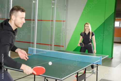 man and woman play ping pong. young guy holding a racket. © Olek