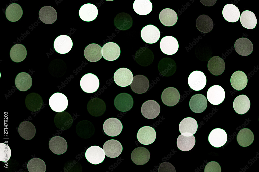 Unfocused abstract colourful bokeh black background. defocused and blurred many round green light Unfocused abstract colourful bokeh black background. defocused and blurred many round green light