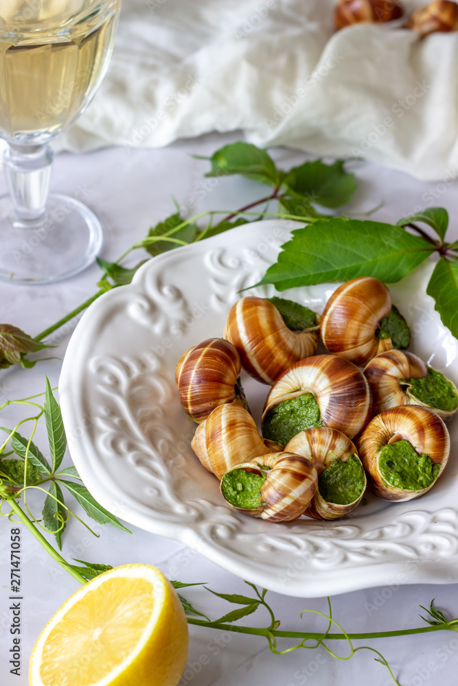 Bourguignonne snail with lemon. Marble background. French cuisine.