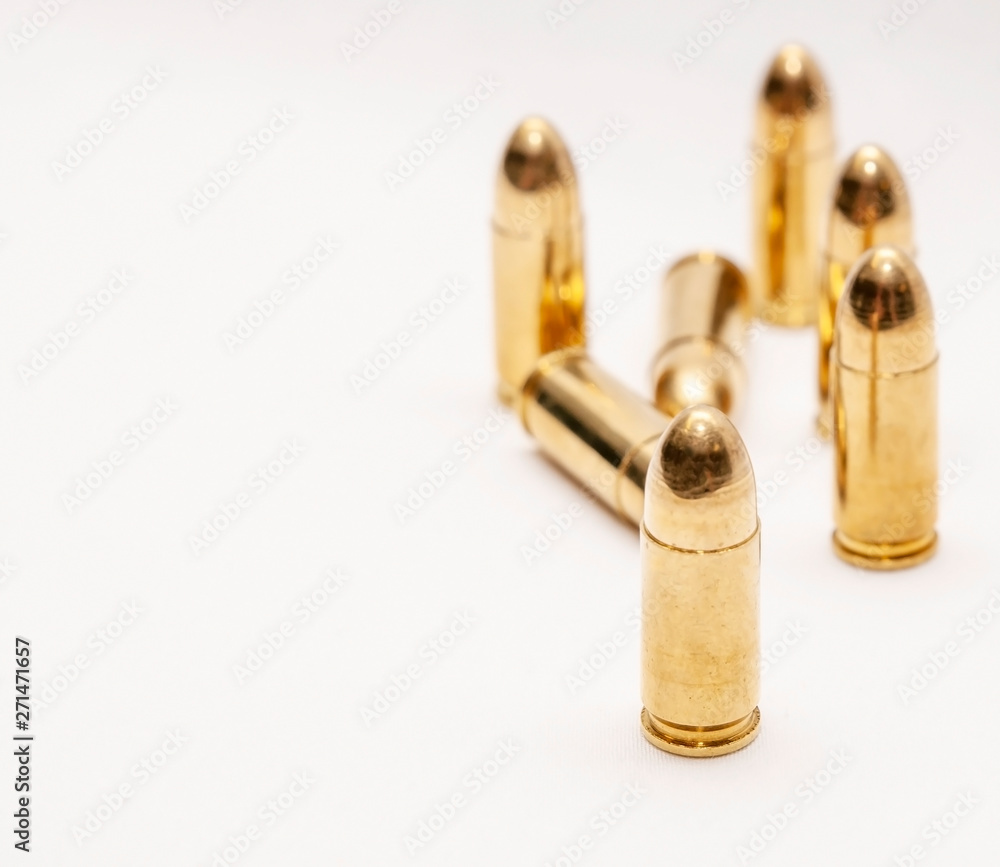 Seven full metal jacket 9mm bullets on a white background with room for text