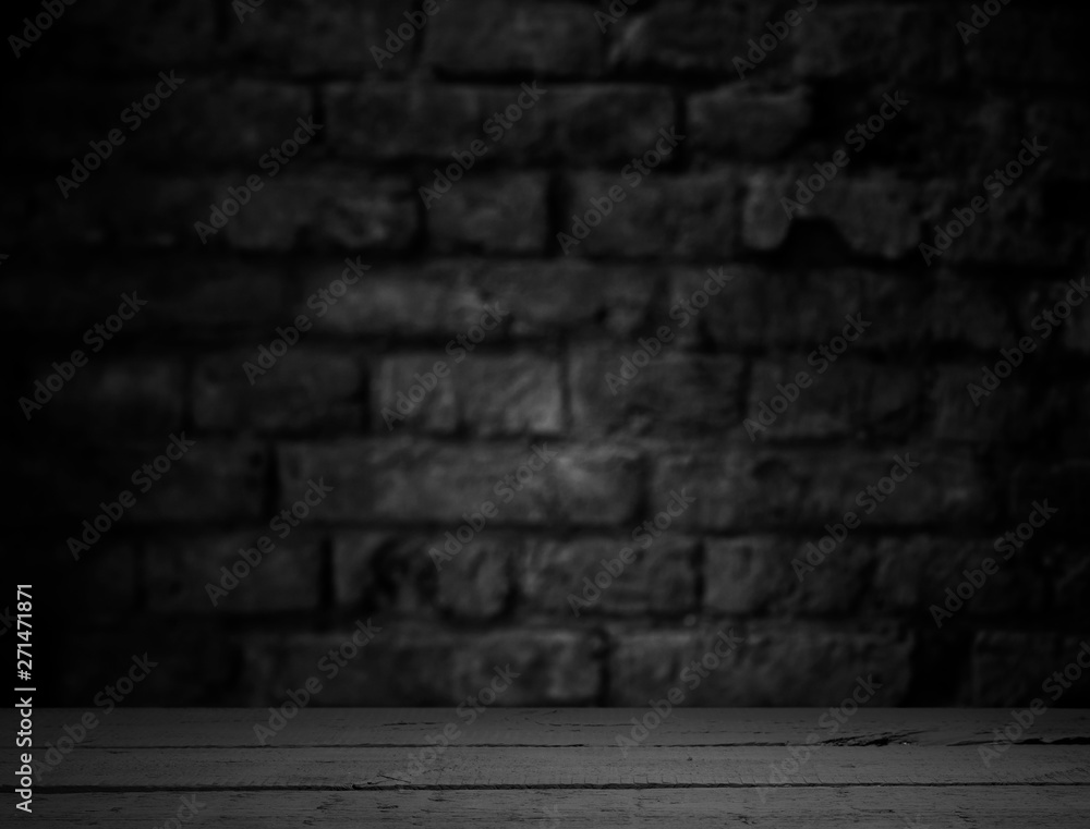 Old wood table with blurred concrete block wall in dark room background. Old wood table with blurred concrete block wall in dark room background.