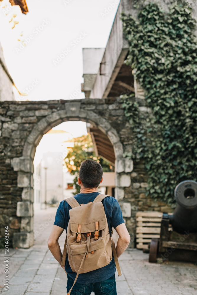 man backpack tourist looks sights old city