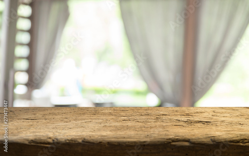 Empty of wood table top on blur of curtain with window view green from tree garden background.For montage product display or design key visual layout © kishivan