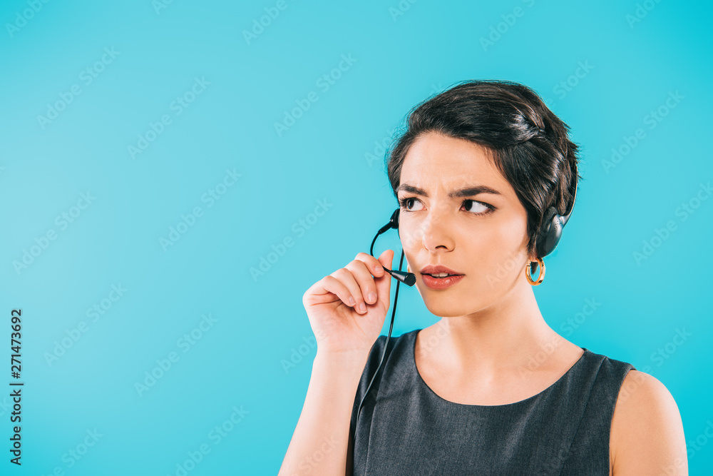 thoughtful mixed race call center operator in headset looking away isolated on blue thoughtful mixed race call center operator in headset looking away isolated on blue