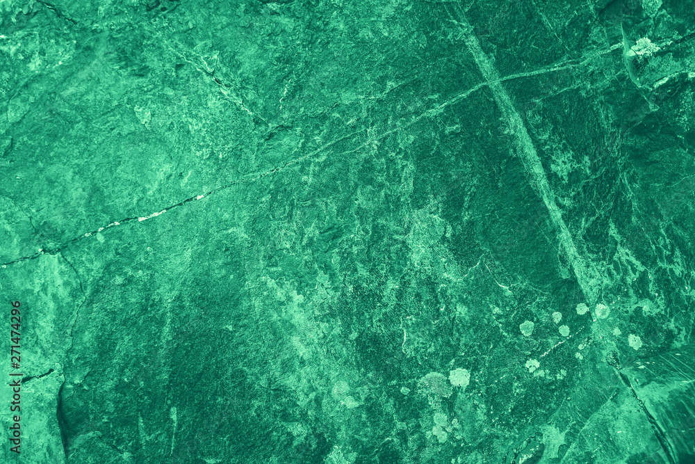 Vintage green background. Rough painted wall of emerald color. Imperfect plane of virid colored. Uneven old decorative toned backdrop of green tint. Texture of emerald hue. Ornamental stony surface.