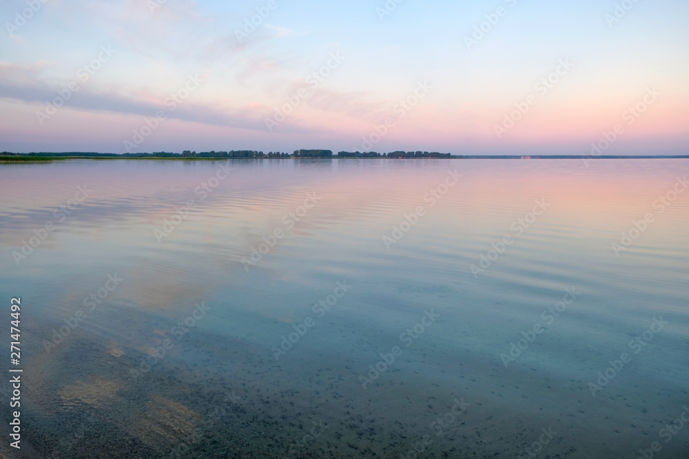 Pink dawn on the Svityaz Lake in Ukraine. Still on the water. Copy space.