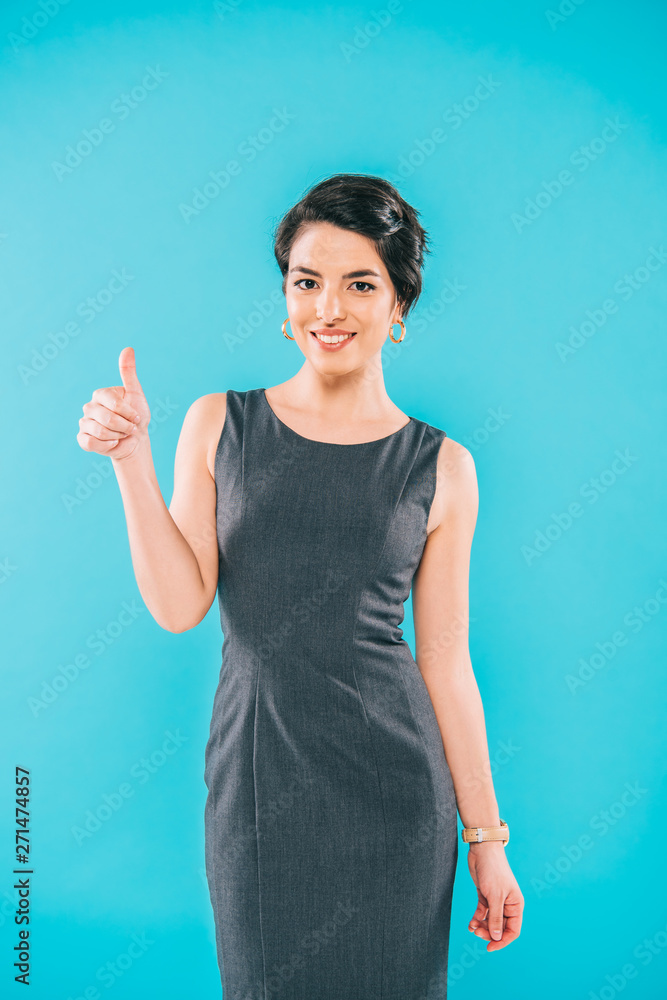 cheerful mixed race woman showing thumb up while looking at camera isolated on blue cheerful mixed race woman showing thumb up while looking at camera isolated on blue