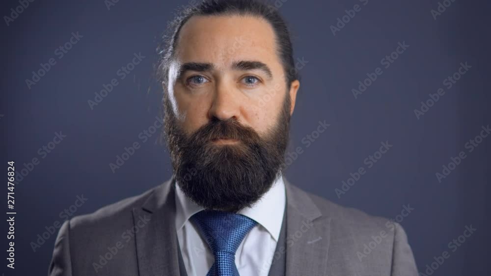 Mature Serious Beardy Businessman In Grey Suit Standing Middle Office. Looking Thoughtful After Business Meeting. Mature Serious Beardy Businessman In Grey Suit Standing Middle Office. Looking Thoughtful After Business Meeting.