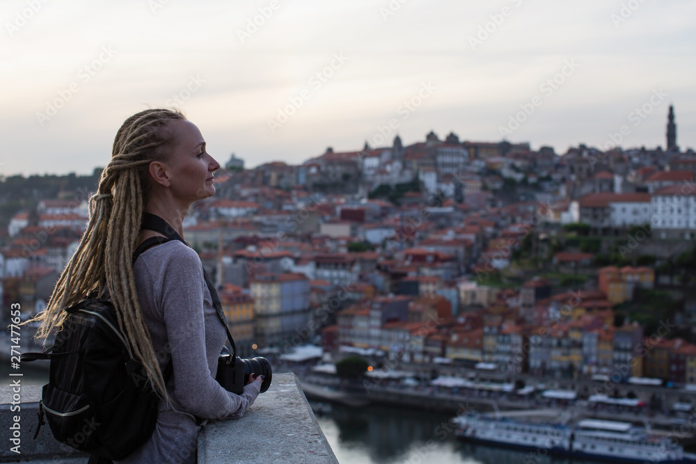 Young woman with dreadlocks on view point opposite Ribeira on Douro river, Porto, Portugal.