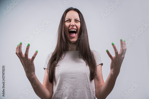 Angry annoyed female gestures with annoyance, screams loudly