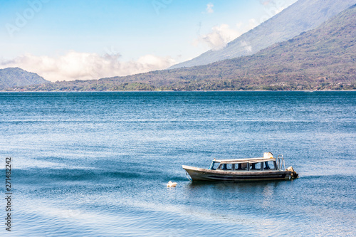 Moored boat on lake with Toliman & Atitlan volcanoes behind at Lake Atitlan, Guatemala