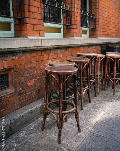 wooden empty bar stools in dublin outside on street at local pub in temple bar - symbol for party