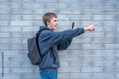 Photos Teenager pointing to something he is recording with his cellphone