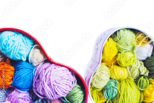 Heart-shaped boxes with knitted multi-colored skeins of yarn on a white background isolated. Crochet and knitting. Women's favorite work.