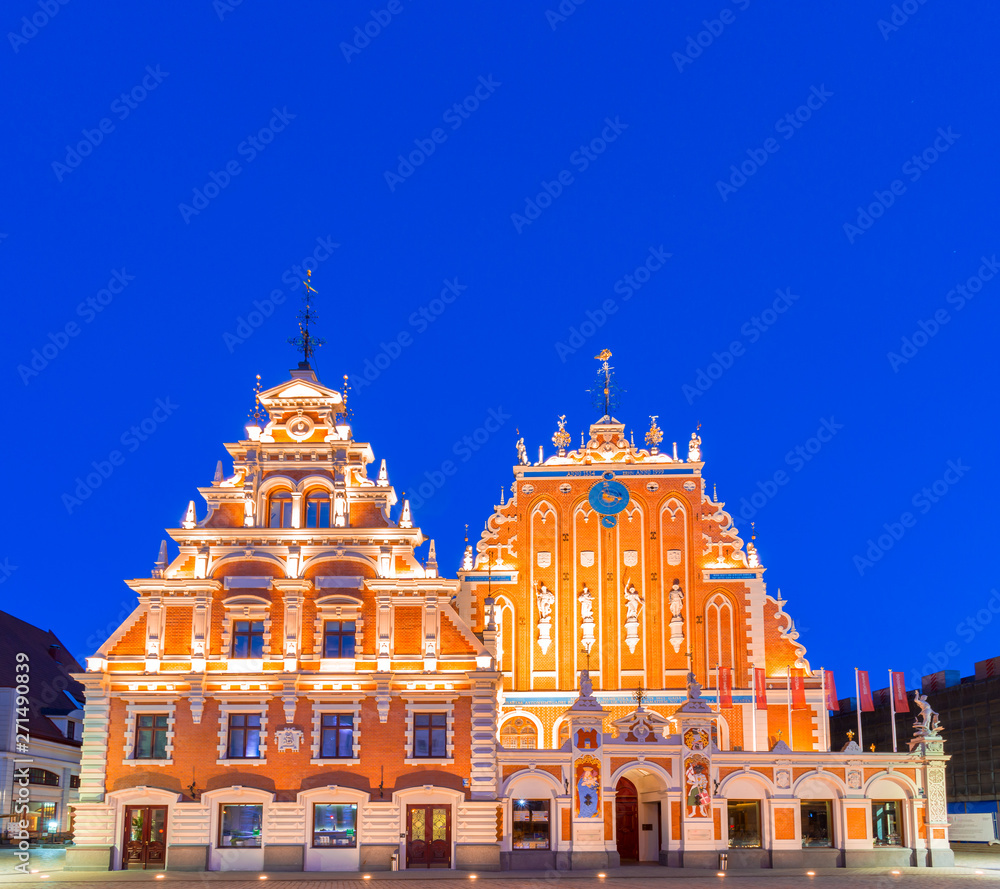 House of the Blackheads (Melngalvju nams) - ornate historical building on Town Hall Square in Riga, the capital of Latvia, at night, artificially illuminated, under clear, dark blue sky. Copy space.