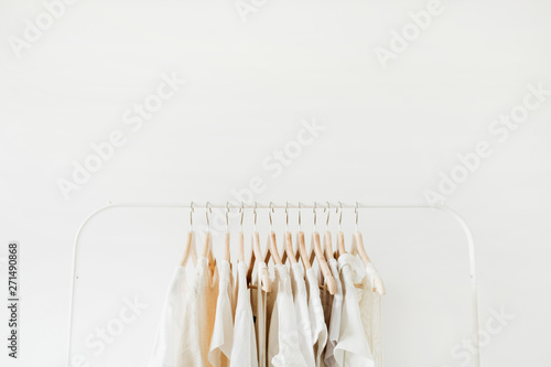 Minimal fashion clothes concept. Female blouses and t-shirts on hanger on white background. Fashion blog, website, social media hero header template.