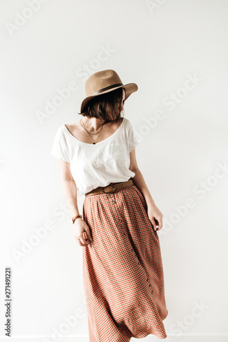 Young pretty woman in long skirt, hat, white blouse on white background. Fashion trendy stylish clothes look. photo