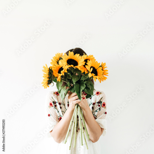 Young pretty woman with sunflowers bouquet on white background.