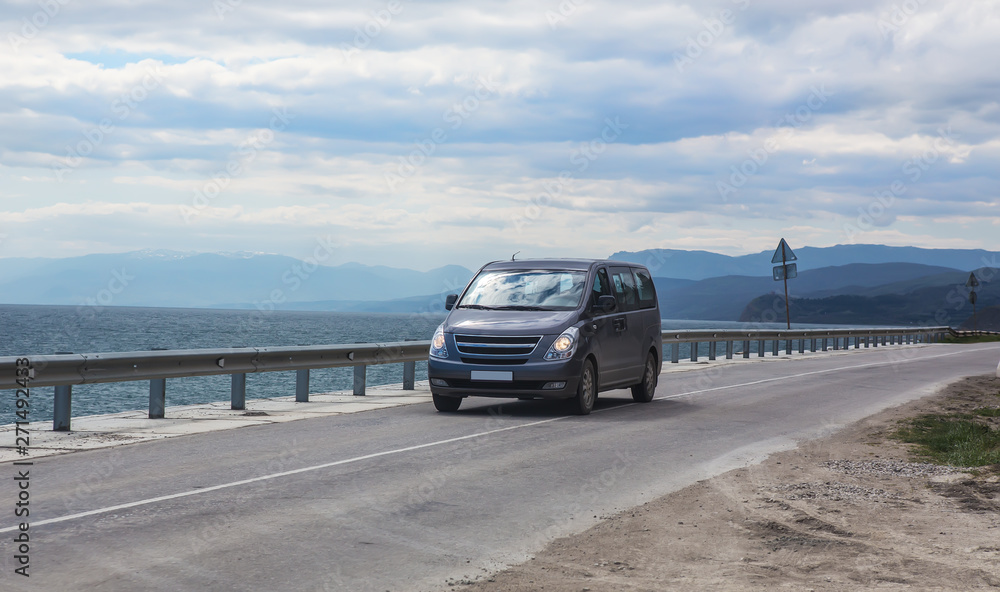 Fototapeta premium Minivan moves on the highway along the sea