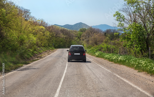 Car Moves along a winding road in the mountains during