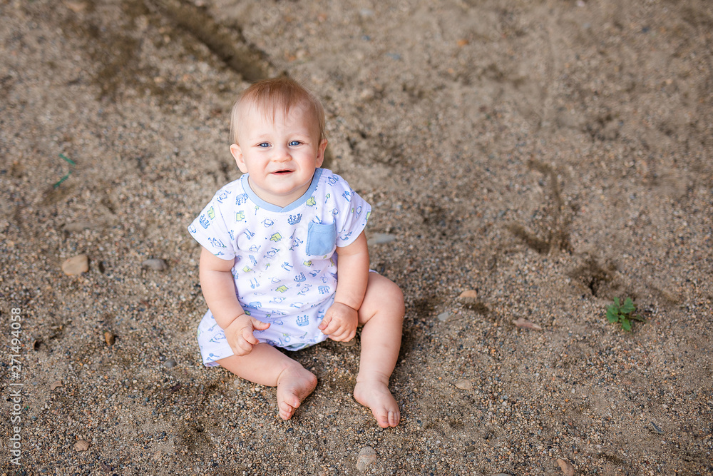 Summer portrait of happy funny baby boy outdoors on rocks. Child learning to crawl Summer portrait of happy funny baby boy outdoors on rocks. Child learning to crawl