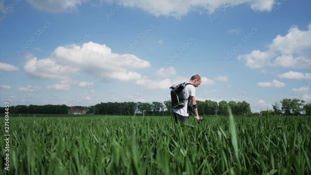 Man with metal detector searching for lost old objects in field Man with metal detector searching for lost old objects in field