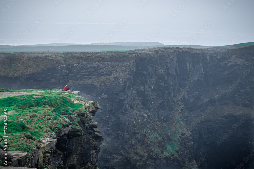 Women sitting on the cliff's edge at th Cliffs of Moher