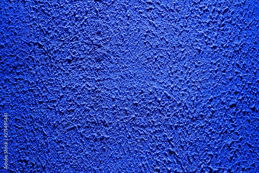 Brightly lit surface covered with bright blue plaster. Trend color Brightly lit surface covered with bright blue plaster. Trend color