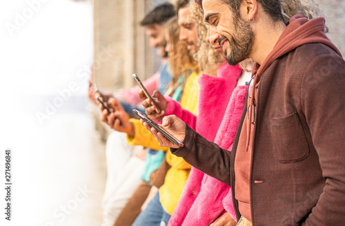 Group of multiracial people standing watching with their cell phones. Young people always connected to the internet and social network concept. Image fades to pure white to leave room for text.