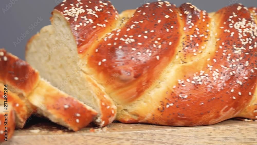 Step by step. Slicing freshly baked challah bread with sesame and poppy seeds. Step by step. Slicing freshly baked challah bread with sesame and poppy seeds.