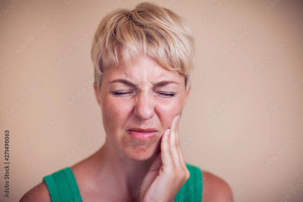 Woman feels strong tooth pain isolated. People, healthcare and medicine concept Woman feels strong tooth pain isolated. People, healthcare and medicine concept