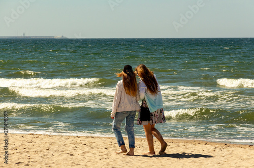 girls are  walking by the sea