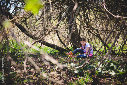 Girl Wearing Pink Rubber Boots Playing Under a Tree in the Spring