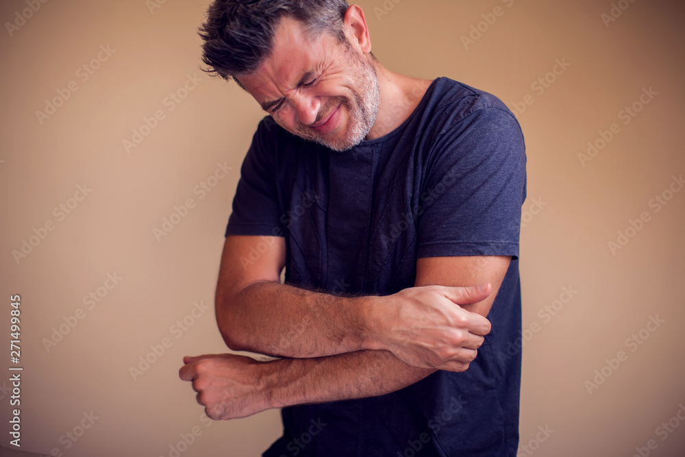 Man feels pain in elbow isolated. People, healthcare and medicine concept Man feels pain in elbow isolated. People, healthcare and medicine concept
