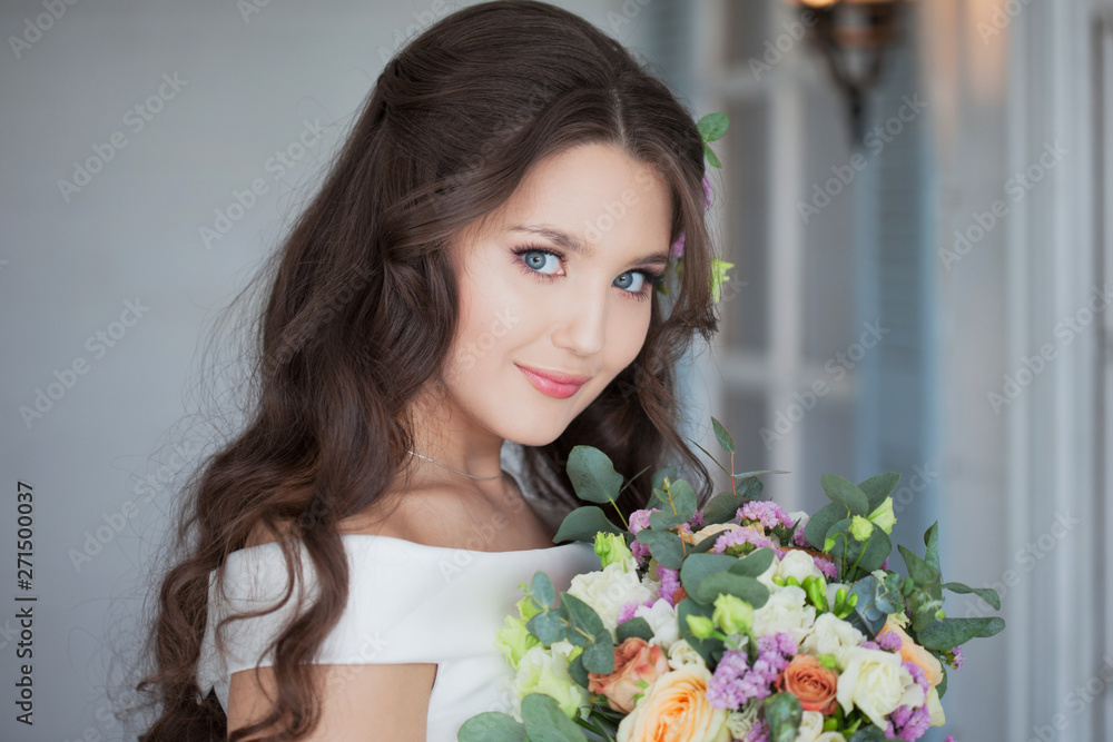 Portrait of a young beautiful bride woman in a white dress