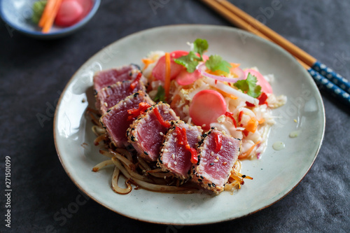 Sesame seeds crusted seared tuna with spicy asian salad and pickled radishes