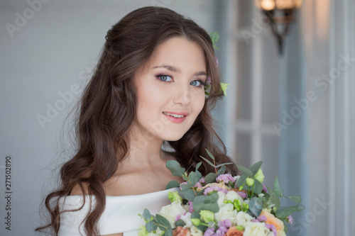 Portrait of a young beautiful bride woman in a white dress