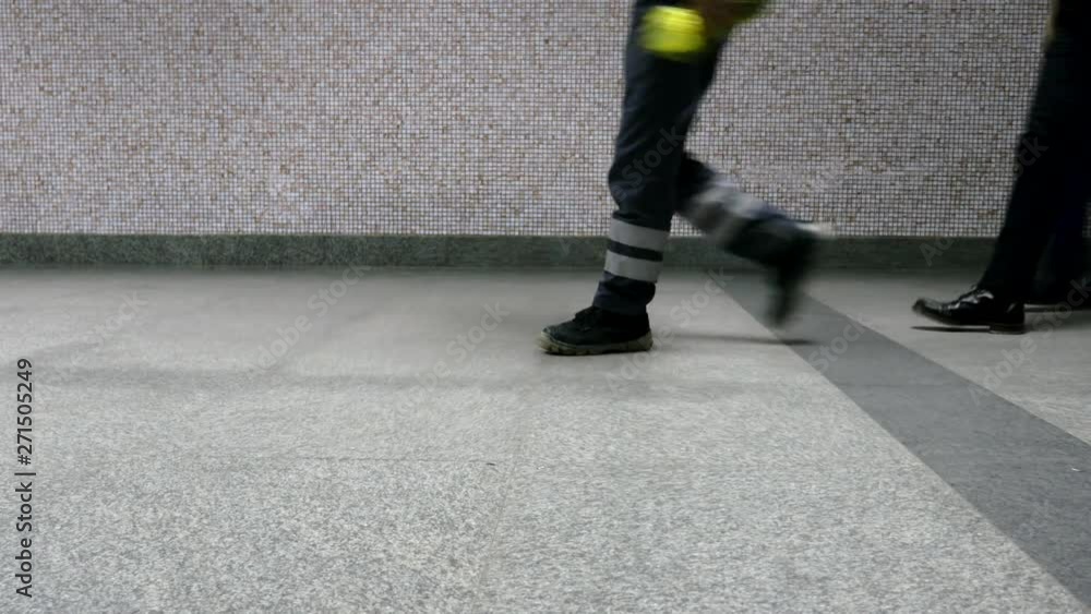 Diverse pedestrian feet and legs walking through public tiled area Diverse pedestrian feet and legs walking through public tiled area