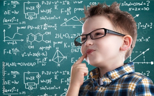 Cute little schoolgirl in glasses on blackboard background