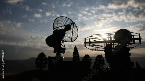 Silhouettes of satellite dishes or radio antennas against night sky. Space observatory or Air defence radar over dramatic sunset sky. Creative artwork decoration. Selective focus