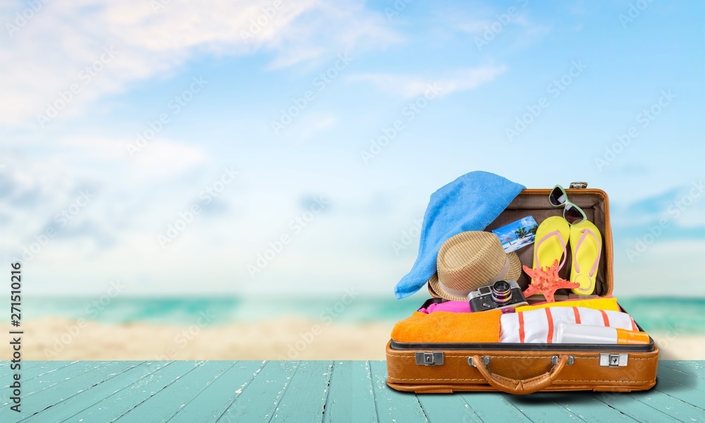 Retro suitcase with travel objects  on sea background - obrazy, fototapety, plakaty 