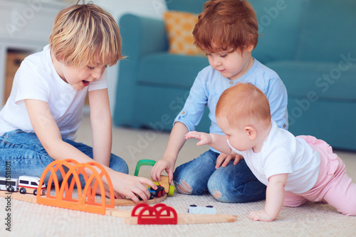 cute kids, siblings playing toys together on the carpet at home