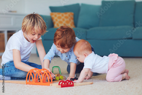 cute kids, siblings playing toys together on the carpet at home