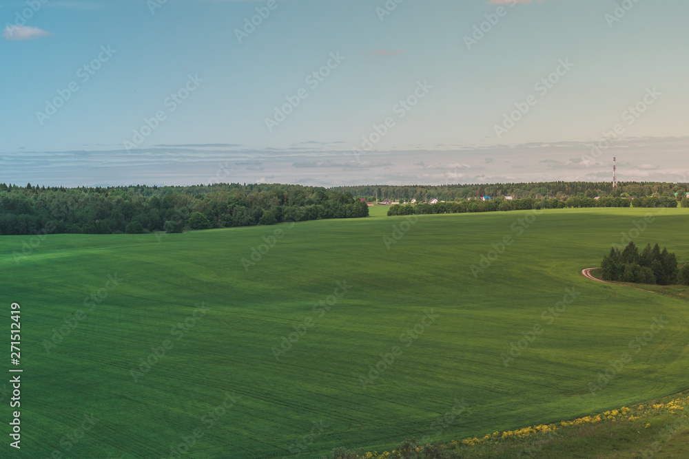 Colorful Bright Sunny Green Field Landscape With Blue Cloudy Sky, Trees And Hills Colorful Bright Sunny Green Field Landscape With Blue Cloudy Sky, Trees And Hills