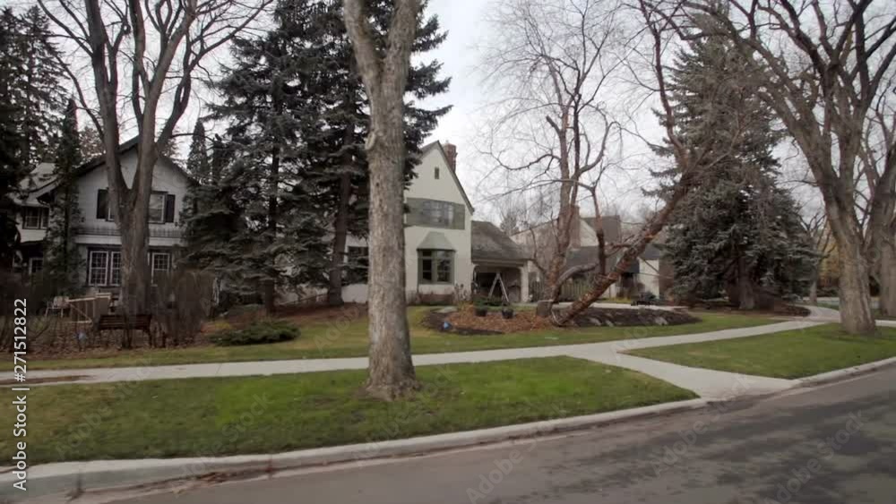 View down a street of an established neighbourhood with houses and large trees; Edmonton, Alberta, Canada View down a street of an established neighbourhood with houses and large trees; Edmonton, Alberta, Canada
