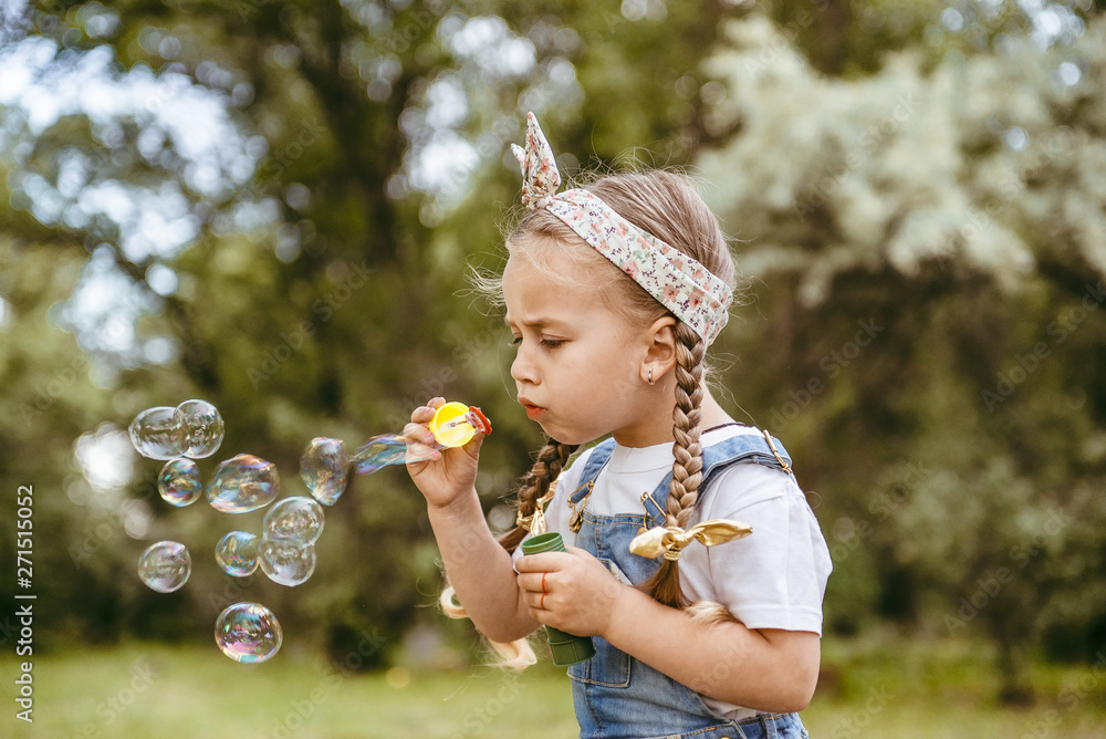 Cute little girl is blowing a soap bubbles Cute little girl is blowing a soap bubbles