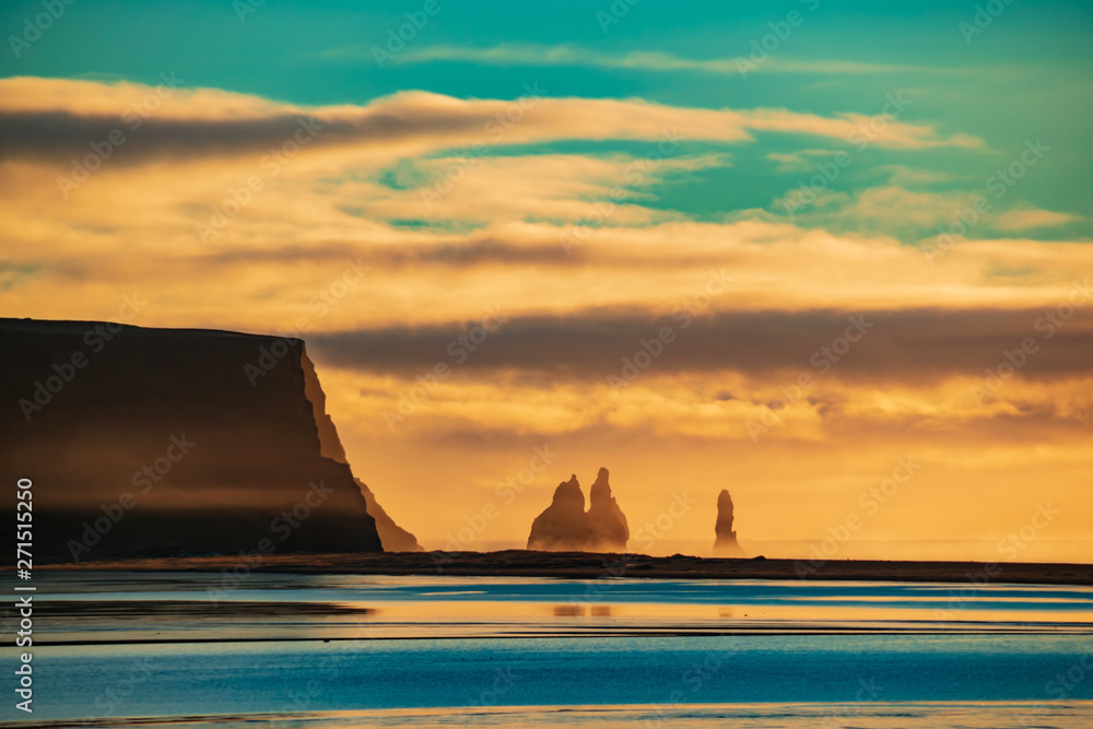 Dawn over the cliffs in the sea. Iceland, Reynisdrangar.