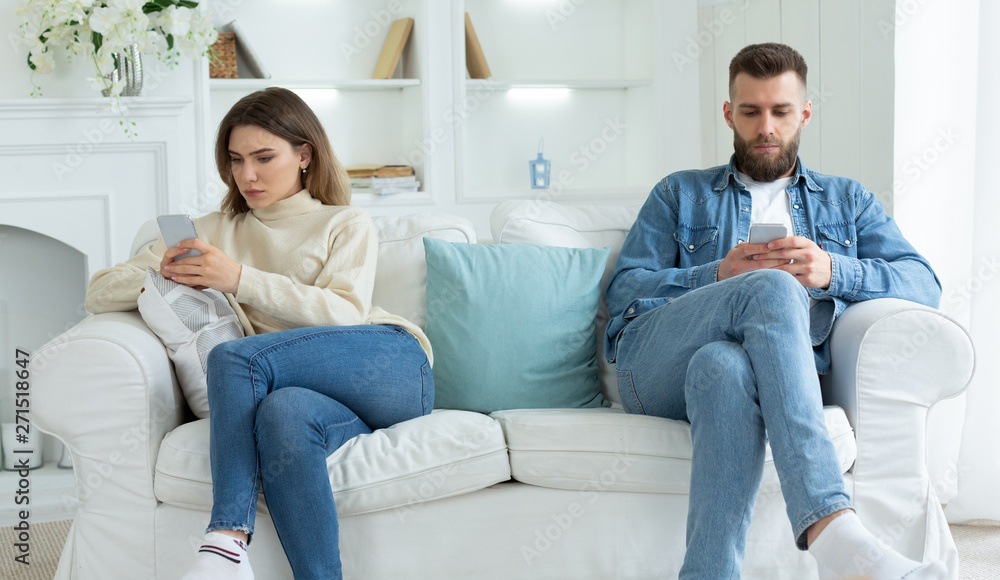 Family quarrel. Couple Staring At Their Own Smartphones