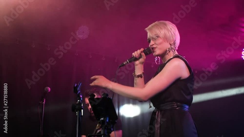 Female singer performs on the stage with guitarist.